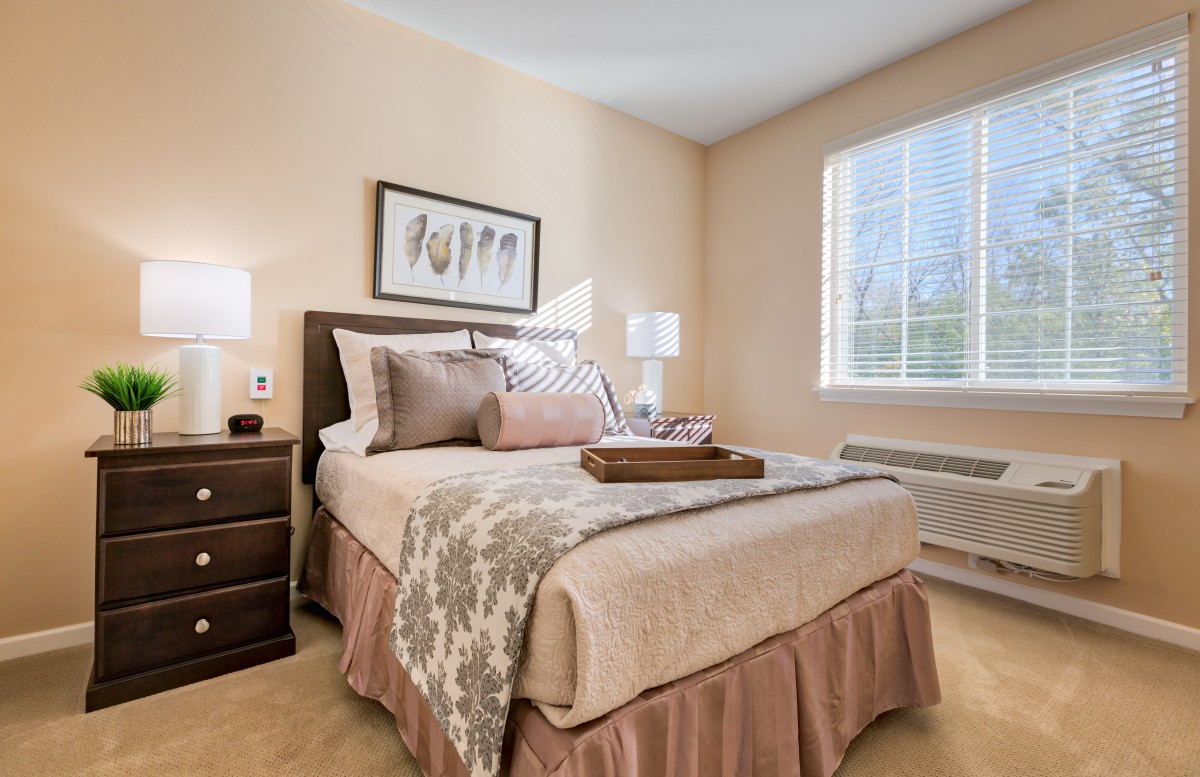 A cozy bedroom with tasteful decor, including a neatly made bed, nightstand, and ambient lighting.