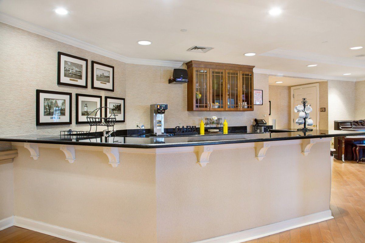 A stylish bar area with a polished counter, decorated with framed pictures and modern furnishings.