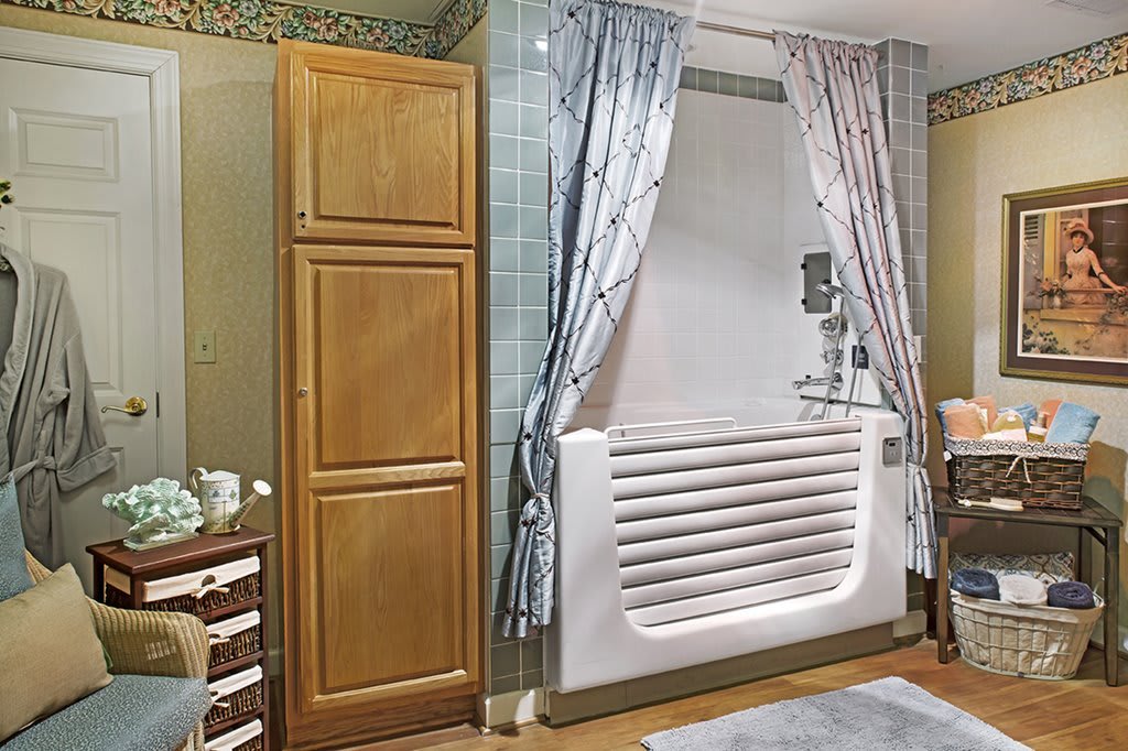 A cozy bathroom with a bathtub, cabinets, and decorative curtains.
