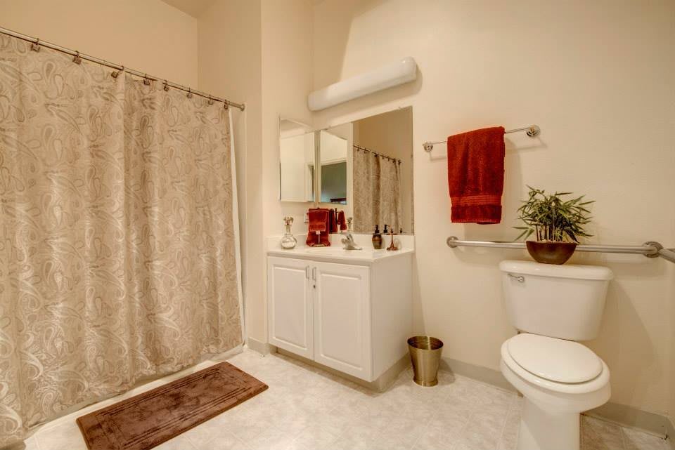 A modern bathroom with a large mirror, vanity sink, and decorative elements.