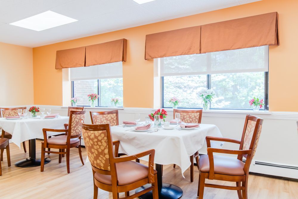 A bright and inviting dining room with elegantly set tables and comfortable chairs.