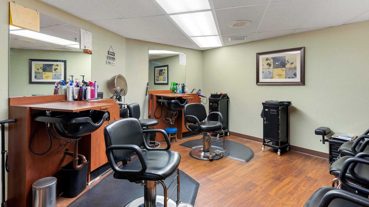 A well-equipped salon interior with hair styling stations and chairs.