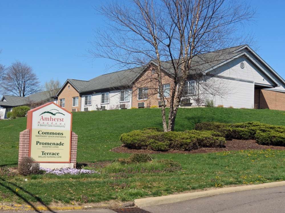A community center building with a sign in front and well-maintained landscaping.