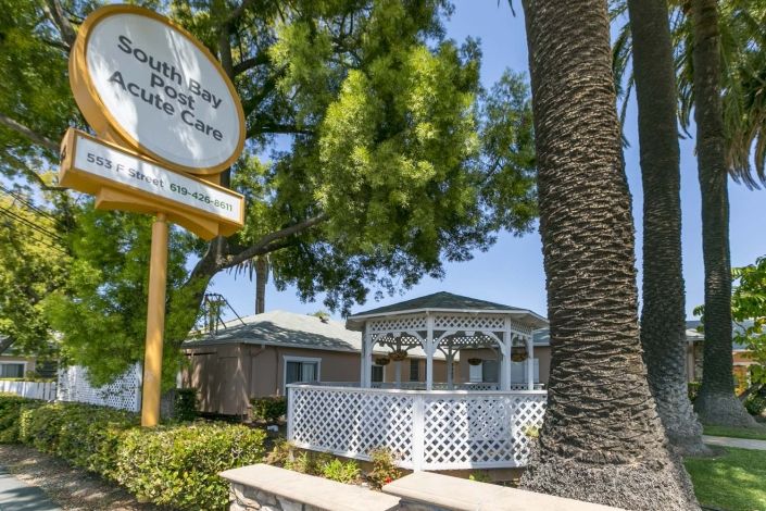 A picturesque gazebo surrounded by lush greenery and a prominent sign.