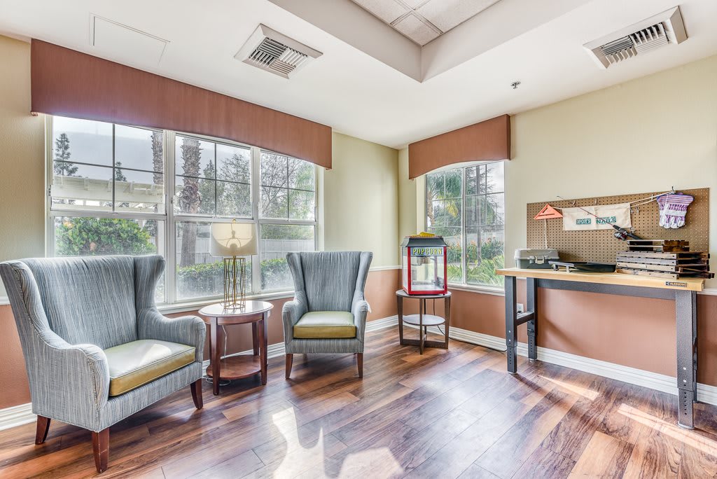 A cozy waiting room with armchairs, a small desk, and large windows providing ample natural light.