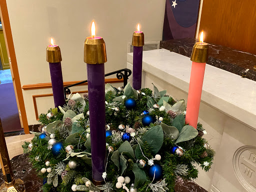 An Advent wreath featuring four lit candles, symbolizing the countdown to Christmas.