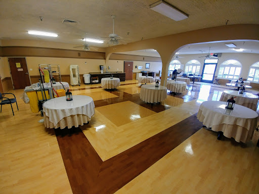 A spacious indoor event venue set up with round tables, ready for a gathering.