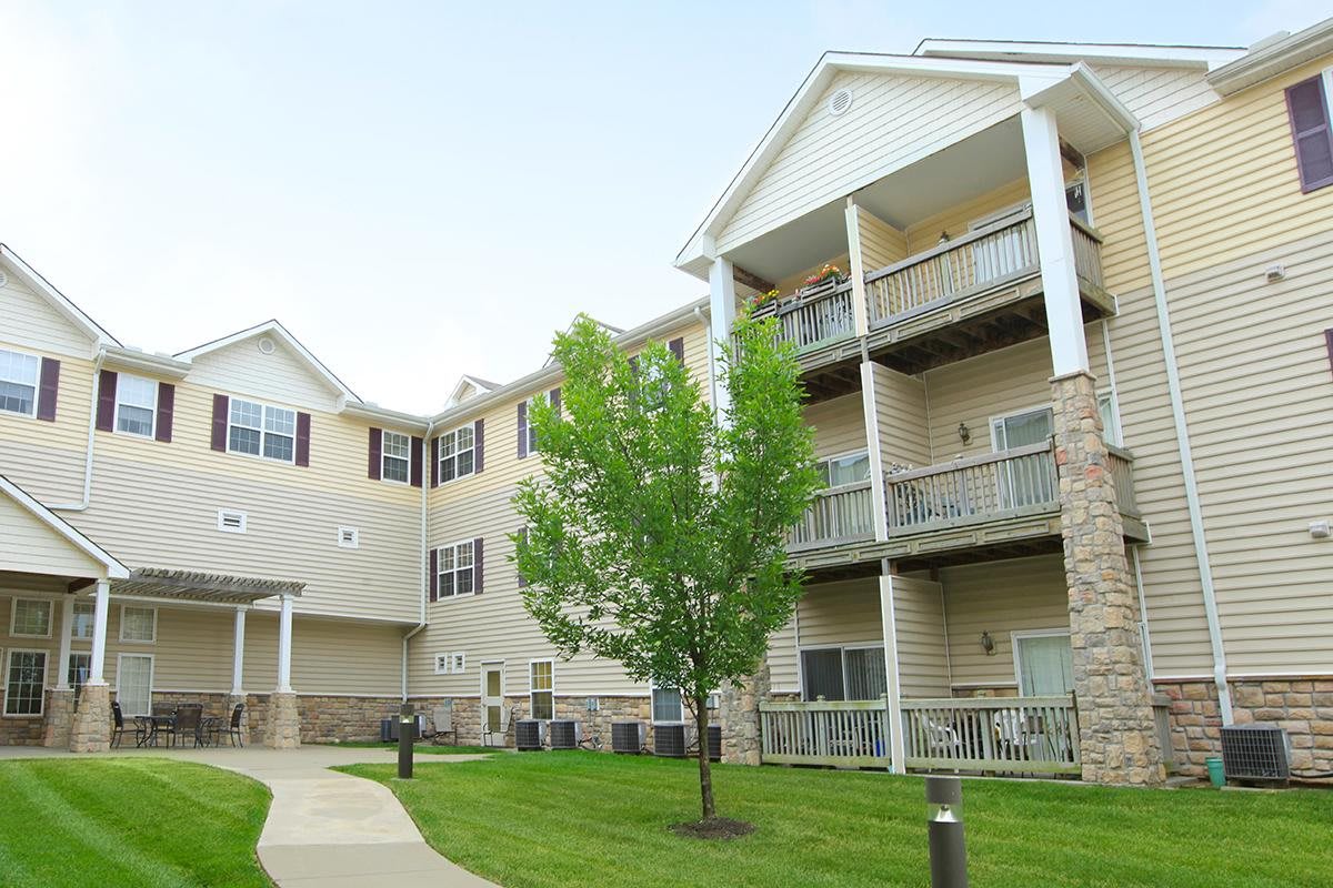 A view of a modern apartment building with balconies and a well-maintained lawn.