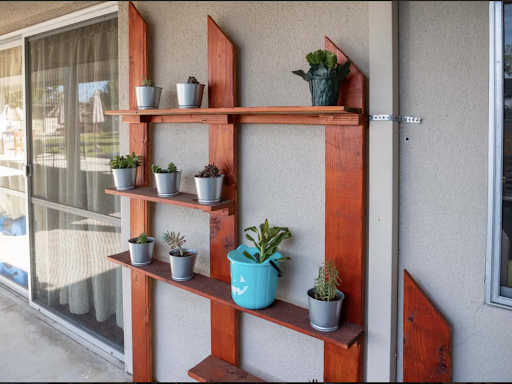 A stylish wooden shelf displaying an assortment of potted plants, perfect for enhancing indoor spaces.