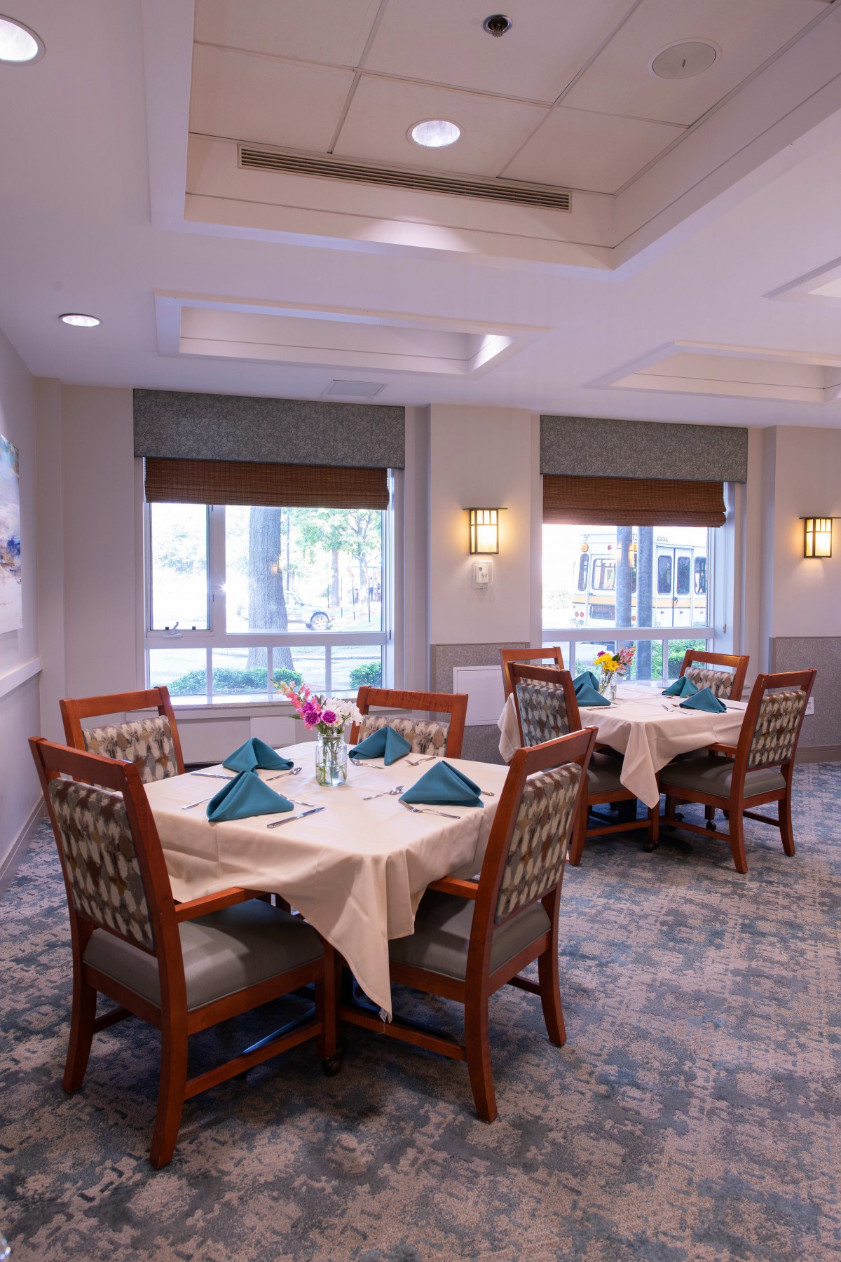 A well-lit dining room with neatly arranged tables and chairs.