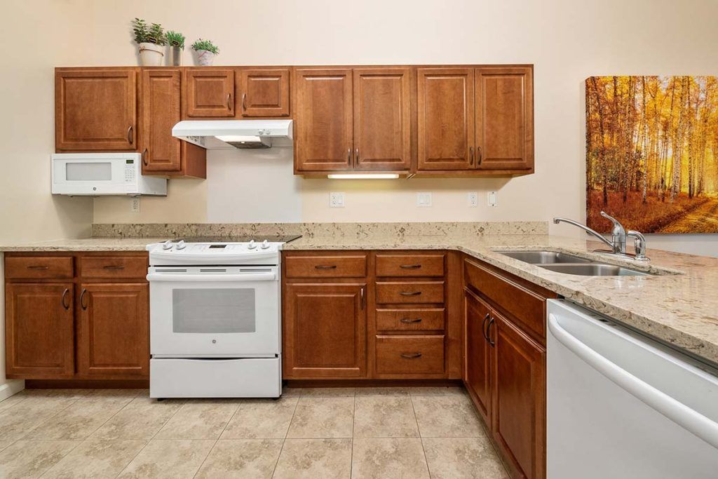 A modern kitchen with wooden cabinets, a white stove, and a dishwasher.