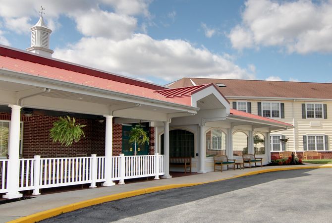 A one-story building with a red roof and white railings in front of a cloudy sky.