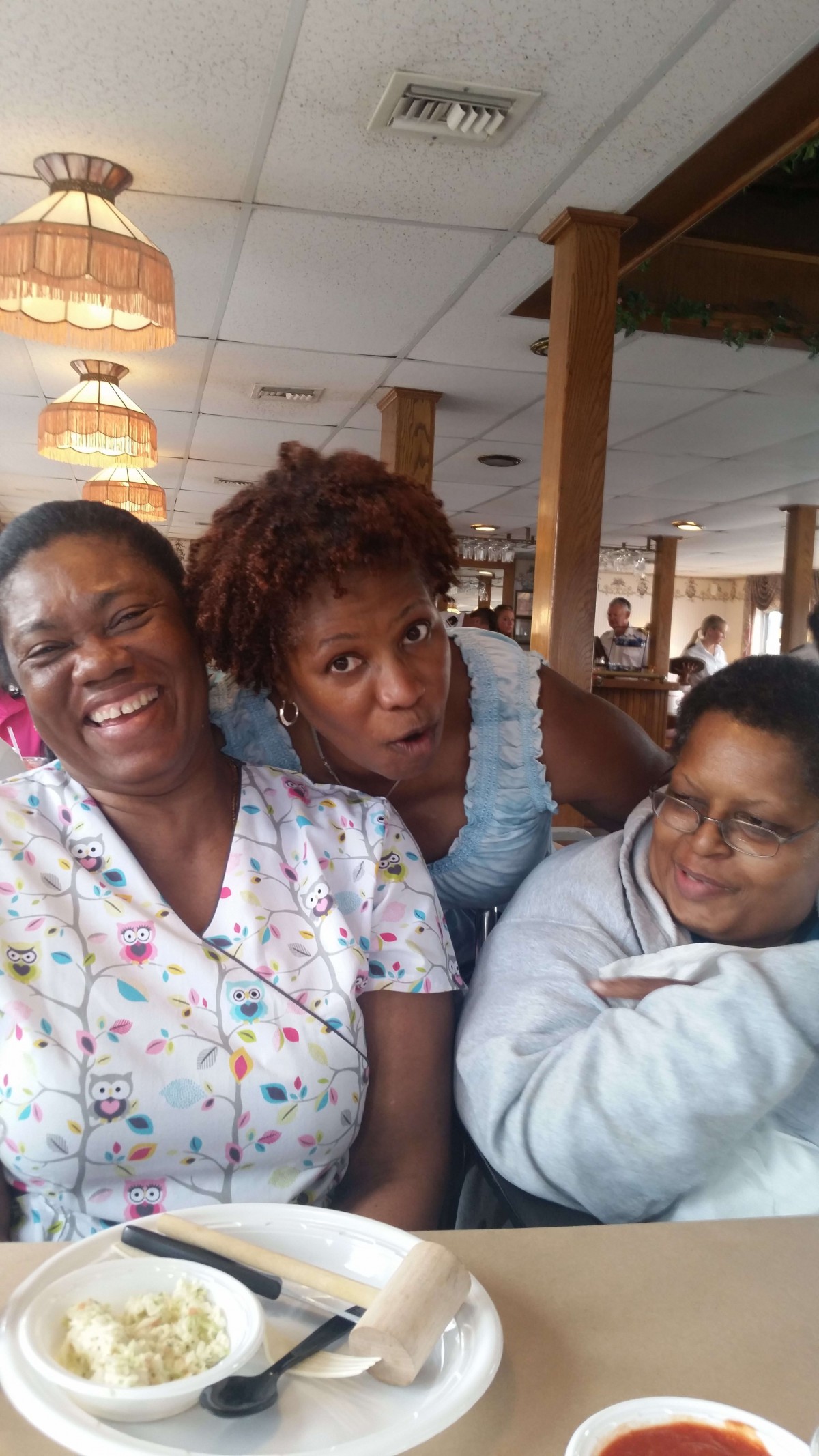 A group of three people smiling together indoors.