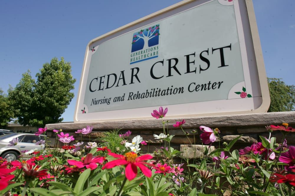 Cedar Crest Nursing and Rehabilitation Center sign surrounded by flowers.