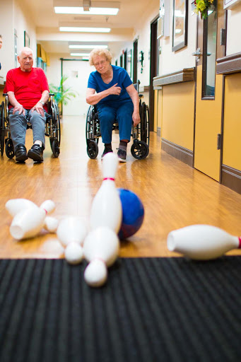 Seniors enjoying a fun bowling activity in a rehabilitation center.