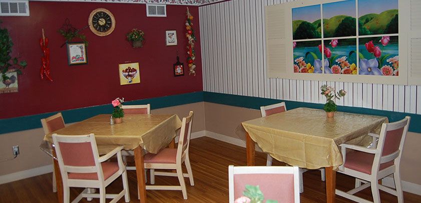 A cozy dining area with neatly arranged tables and chairs, adorned with wall art and decorative items.