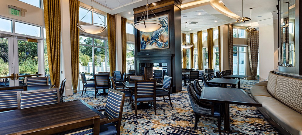 A modern restaurant interior with elegant seating and large windows.