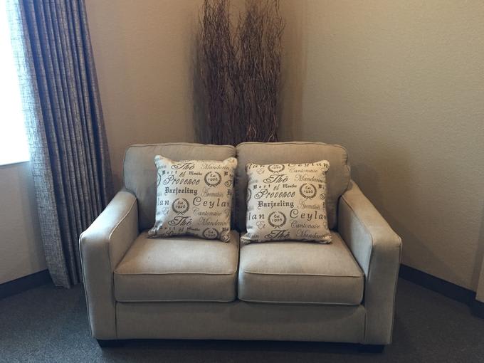 A comfortable beige sofa adorned with patterned pillows in a cozy living room.