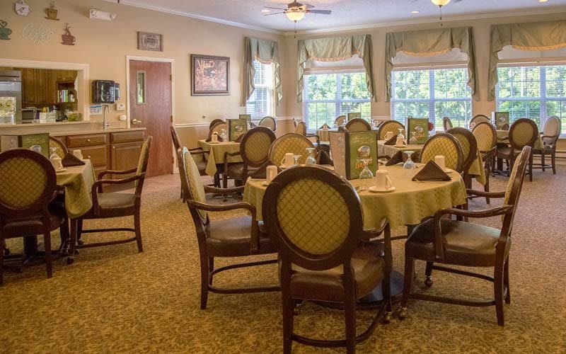 A well-decorated dining room with elegant furniture and large windows.