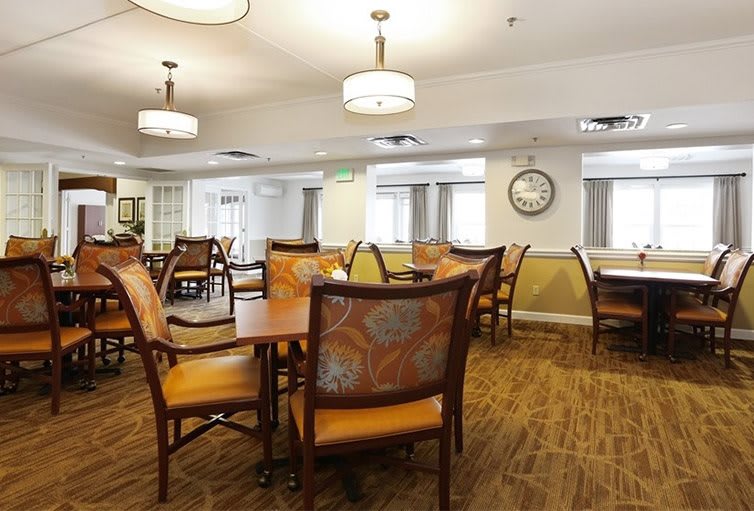 A well-lit dining area with neatly arranged tables and chairs.