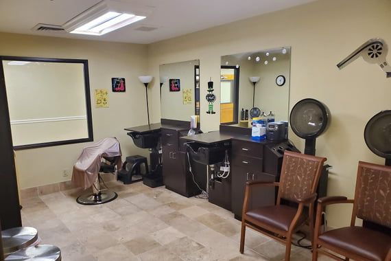 An interior view of a hair salon featuring styling chairs, mirrors, and various salon equipment.
