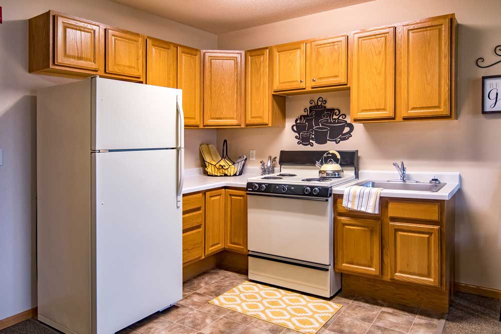 A cozy kitchen with wooden cabinets and standard appliances.