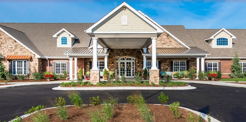 A well-maintained building entrance featuring columns and landscaped surroundings.