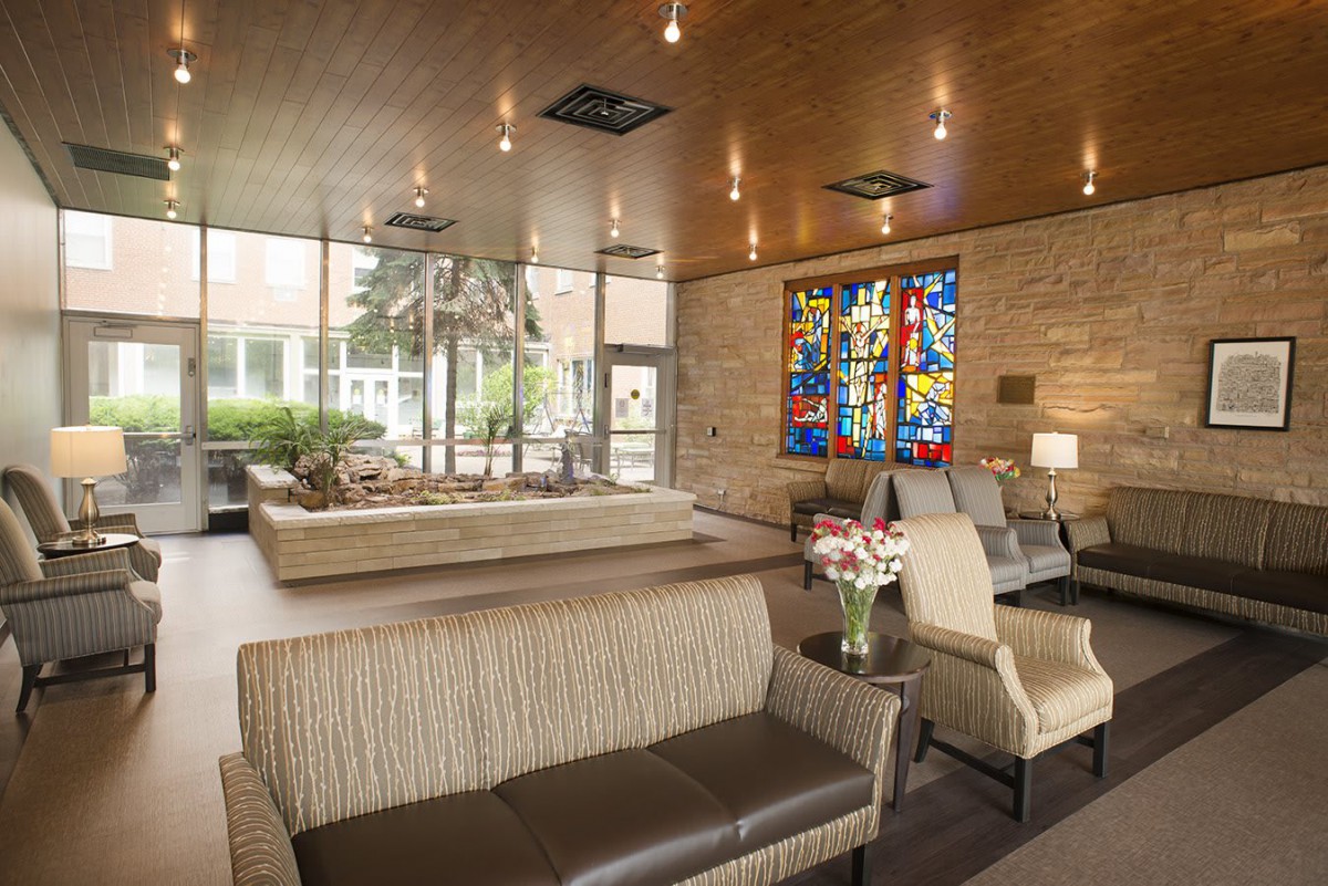 A modern lobby with comfortable seating and a stained glass window feature.