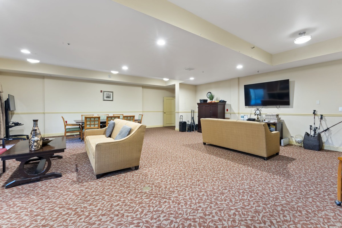 A spacious living room with comfortable seating and a large TV.