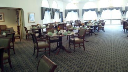 A formal dining room with neatly arranged tables and chairs.