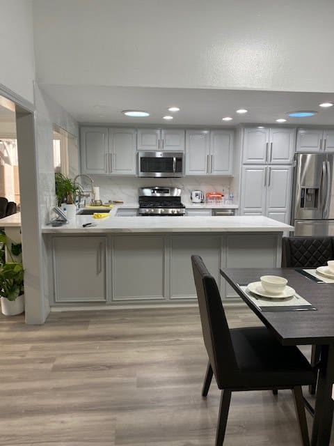 A modern kitchen with sleek appliances and a dining table set for four.