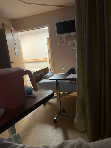 A view of a hospital room containing a bed and medical equipment.