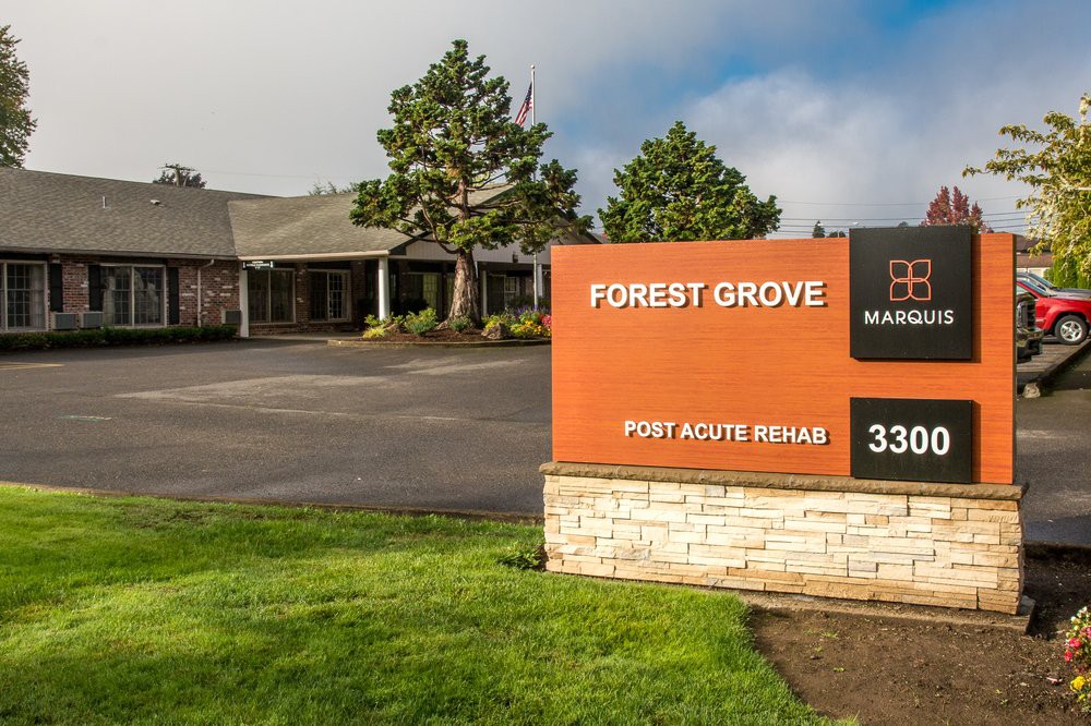 Entrance to a commercial building with a prominent Forest Grove sign and well-maintained landscaping.