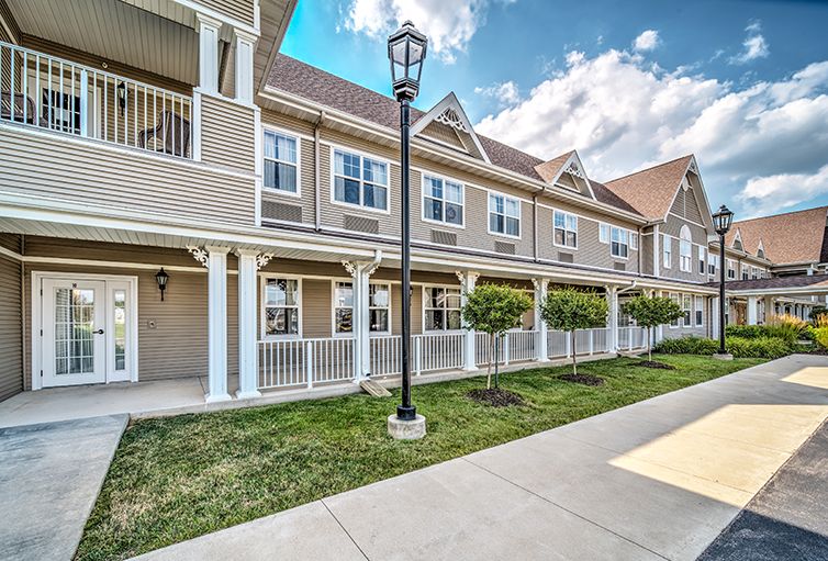 A modern townhouse complex in a suburban setting, featuring a well-maintained exterior and green landscaping.