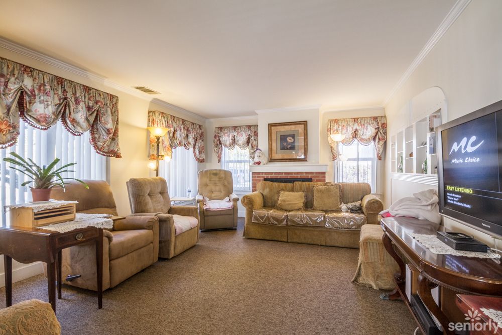 A cozy, traditionally decorated living room with armchairs and a sofa.