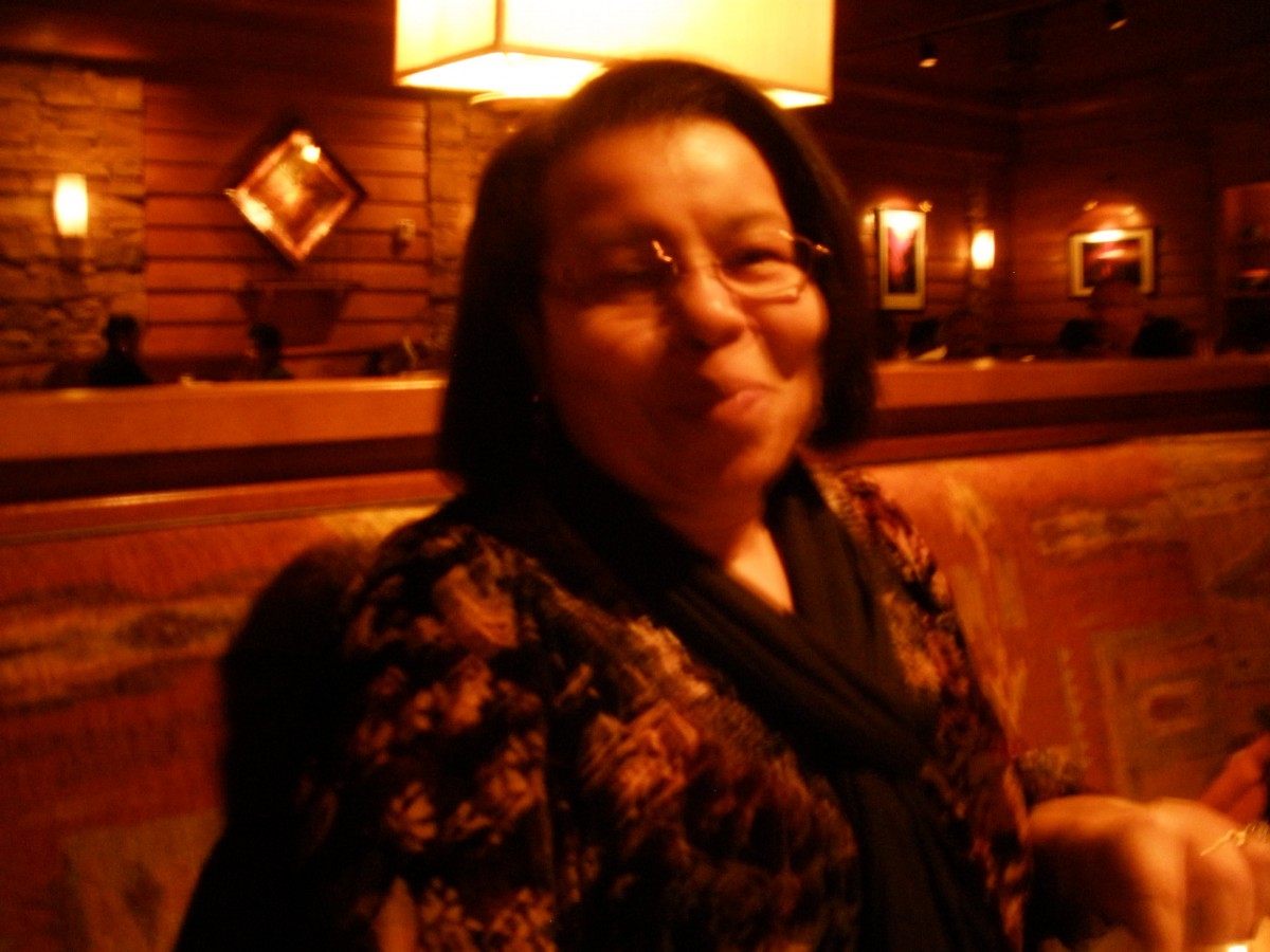 A woman sitting in a dimly lit restaurant.