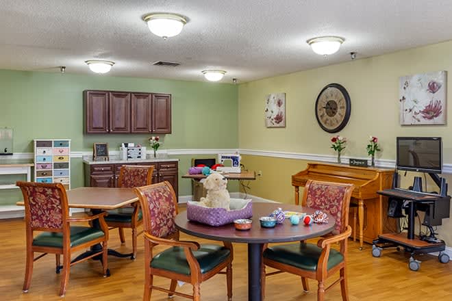 A cozy dining area with tables and chairs, featuring decorative elements and warm lighting.