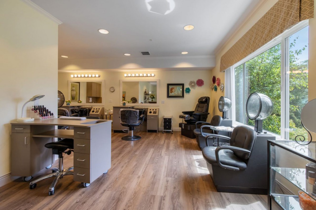 A modern hair salon interior with styling stations and natural lighting.