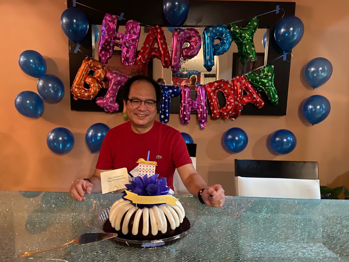 A person celebrating their birthday with a cake and festive decorations.