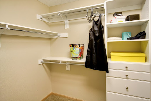 A well-organized closet with shelves and a hanging dress.