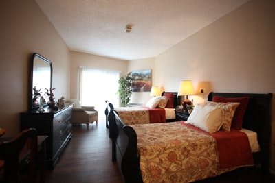 A cozy bedroom with twin beds, elegant decor, and warm lighting.