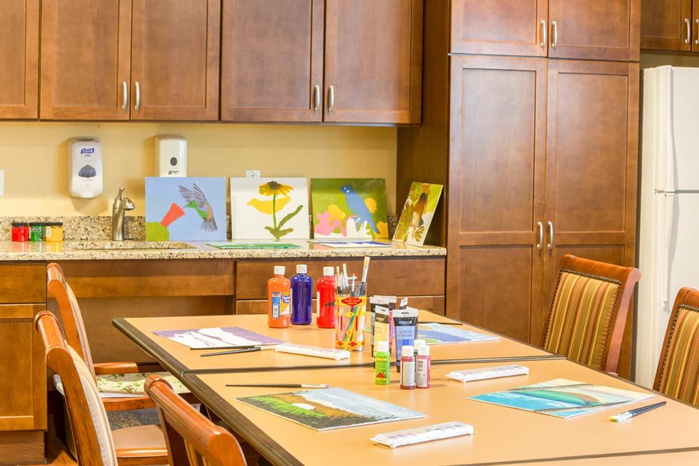 A classroom art setup with painting supplies and artwork displayed on a counter.