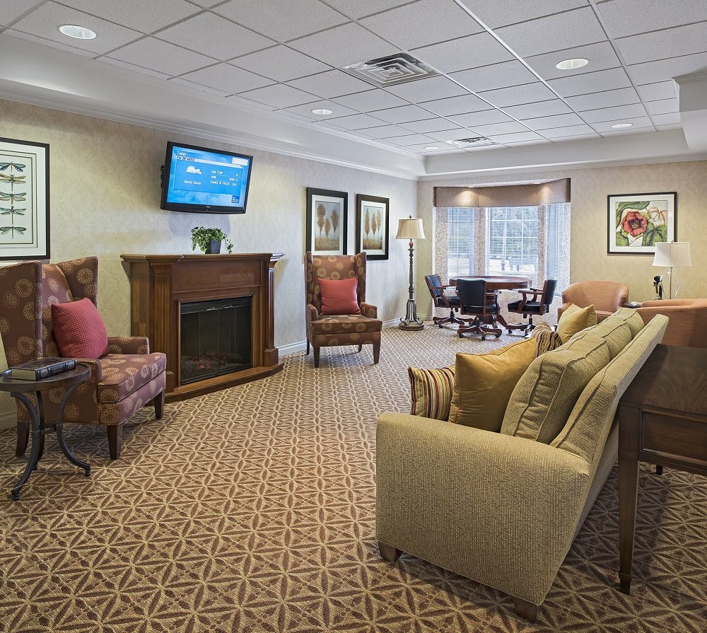 A cozy living room with comfortable seating, a fireplace, and a television.