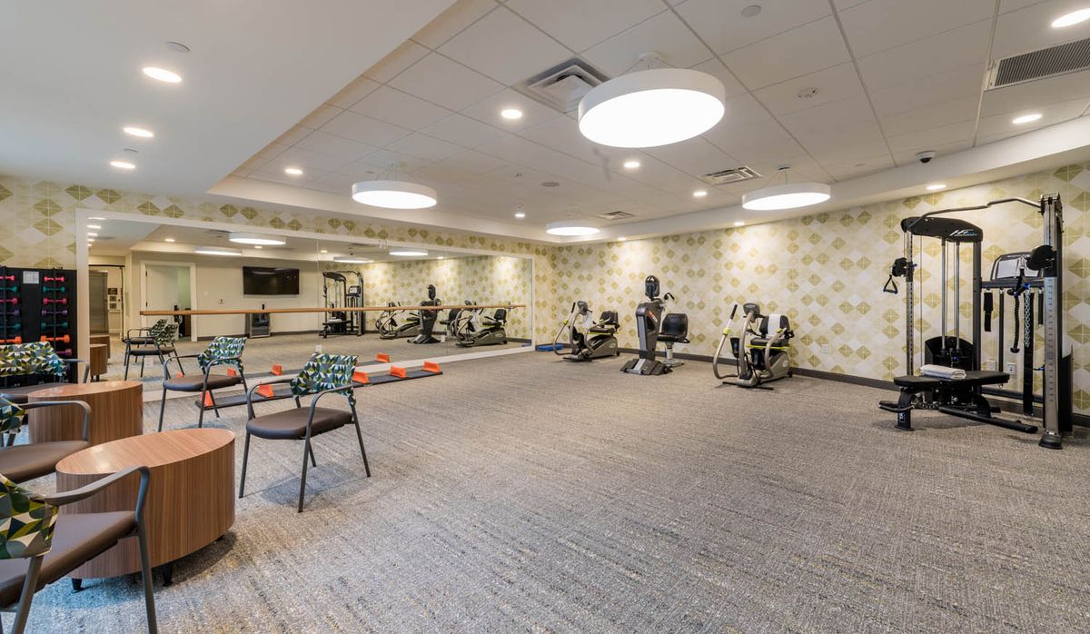 A spacious gym with a variety of exercise equipment and open floor space.