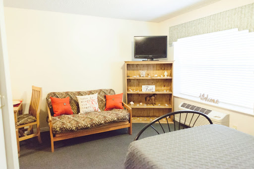 A cozy living space featuring a sofa, television, and shelving.