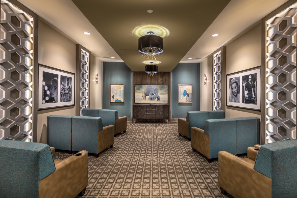 A modern lobby with comfortable seating, stylish chandeliers, and artwork adorning the walls.