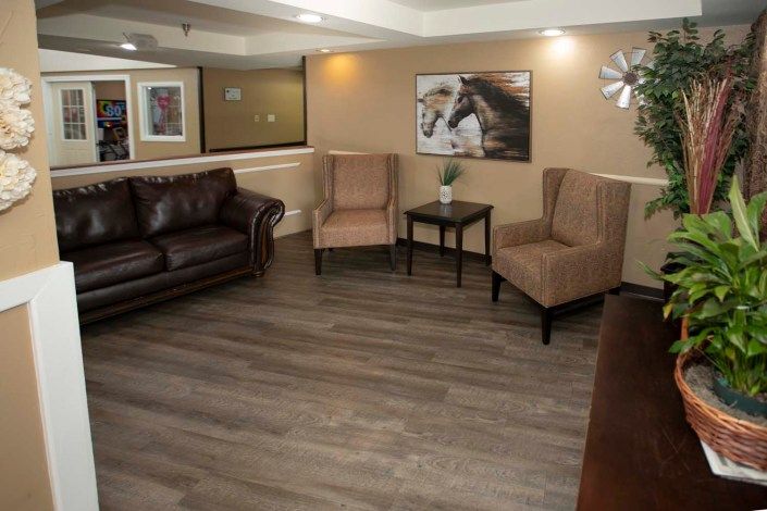 A cozy living room with a sofa, two armchairs, and decorative wall art.