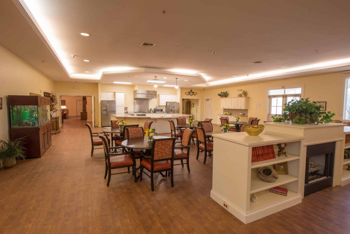 A modern dining area with a view of an open kitchen and elegant furniture.