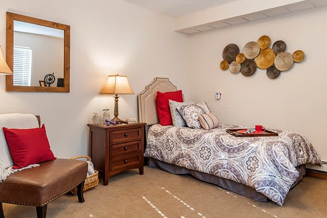 A cozy and stylish bedroom with a single bed, nightstand, and decorative wall elements.
