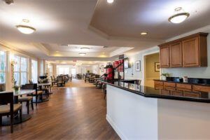 A spacious dining area with a modern design featuring a long counter and multiple tables and chairs.